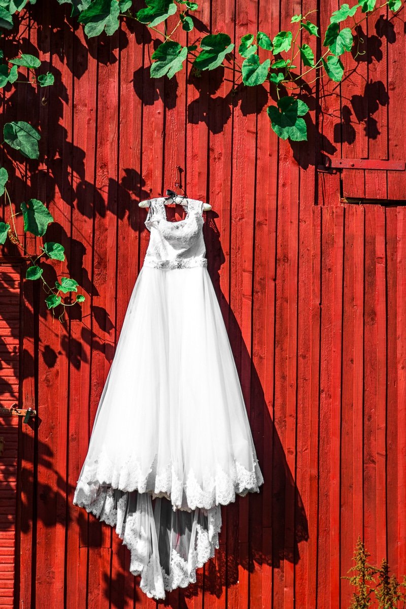 Kāzu foto ar līgavas kleitu uz sarkana fona
